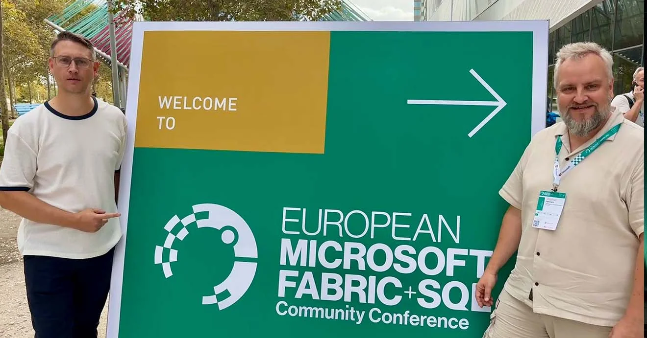 Zwei BI-Experten stehen neben dem Willkommensschild der European Microsoft Fabric + SQL Conference.