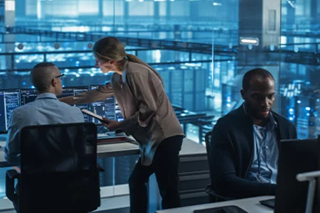 Symbolic image: A team of experts analysing IT systems on monitors in a control room.