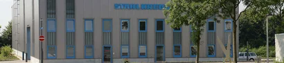 Firmensitz der ERNST KREBS KG in Solingen Fassade mit blauen Fensterrahmen; Schriftzug STAHL KREBS oben; davor Bäume und Mast