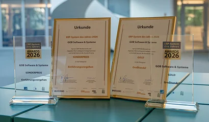 Unsere ERP-Auszeichnungen im GOB-Atrium Zwei Pokale und Urkunden auf dem türkisfarbenen unitop-Würfel im GOB-Atrium in Krefeld.