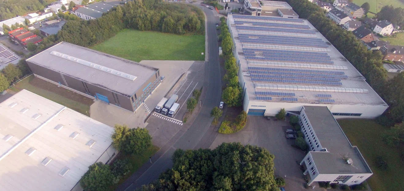 ERNST KREBS KG – Firmensitz Solingen aus der Vogelperspektive Luftaufnahme eines Werksgeländes; Hallendächer mit Solarmodulen und Zufahrtsstraße