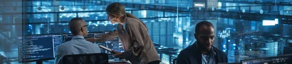 IT-Sicherheitsberatung: Risiken erkennen, Sicherheit stärken Symbolbild: Expertenteam analysiert IT-Systeme an Monitoren in einem Leitstand.