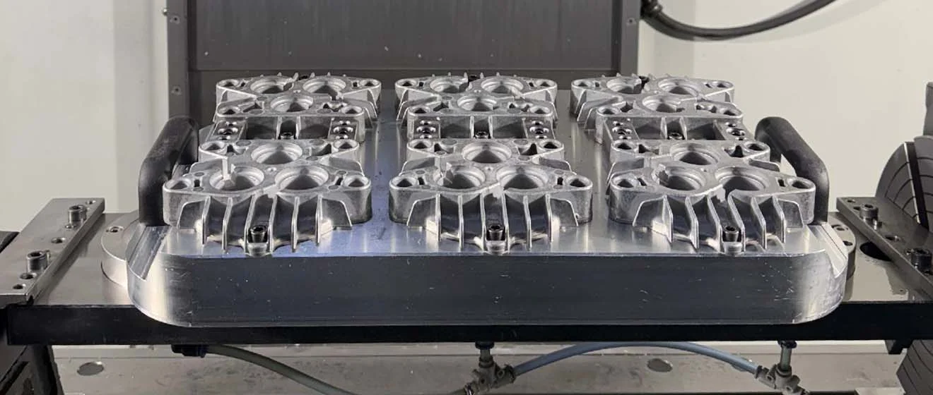 Aluminiumgussfertigung bei J & A Burghaus Mehrere Aluminiumgussteile auf einer Spannvorrichtung in der Fertigung.