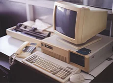 Aus UNIX und COMET TOP entsteht UNITOP Schreibtisch mit analogem Schnurtelefon, Faxgerät, Tastatur, Kabel-Maus und Computer-Röhrenmonitor