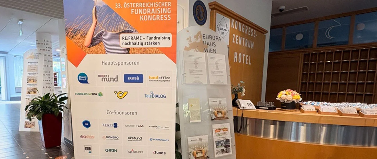 Banner zum 33. Österreichischen Fundraising Kongress neben der Rezeption des Europahauses Wien.