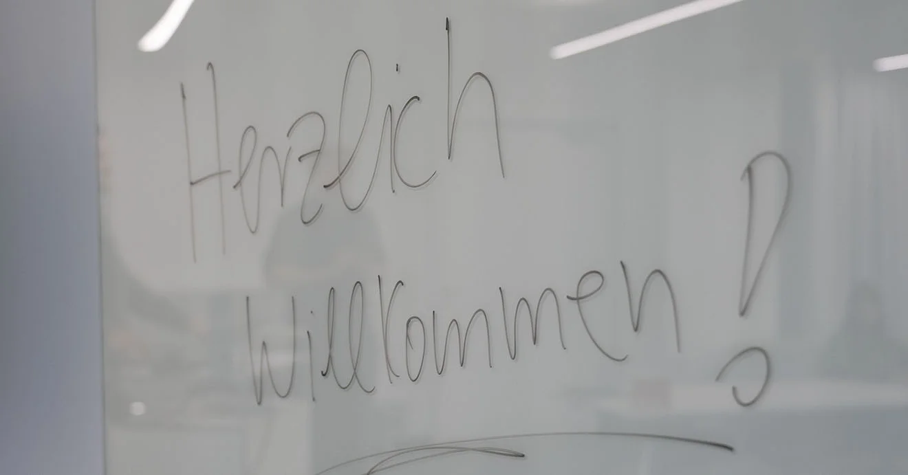 Herzlich willkommen im Team GOB! Handschriftlicher Willkommensgruß „Herzlich Willkommen!“ auf einer Glastafel zum GOB-Trainee-Start.