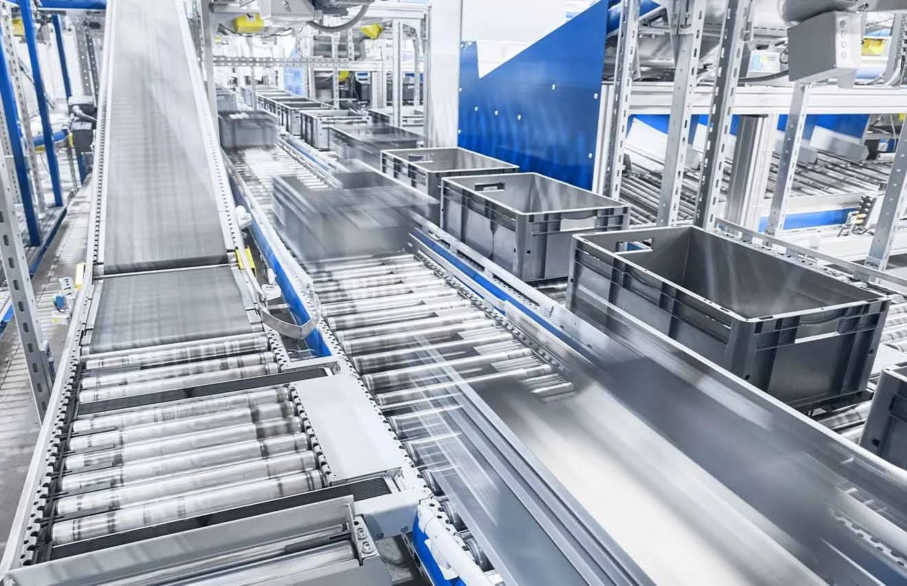 Material flow in series production – networked with unitop Conveyor system with roller tracks and grey containers for fast material flow in series production.