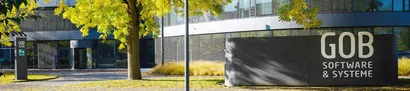 Haupteingang des Gebäudes der GOB Software & Systeme GmbH Frontansicht GOB-Gebäude mit Bäumen mit herbstlich-gelben Blättern