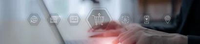 Multichannel-E-Commerce – alle Verkaufskanäle im ERP vernetzt Hände tippen auf Laptop, davor Symbole für Warenkorb, Kunden, Kanäle – Multichannel-E-Commerce.