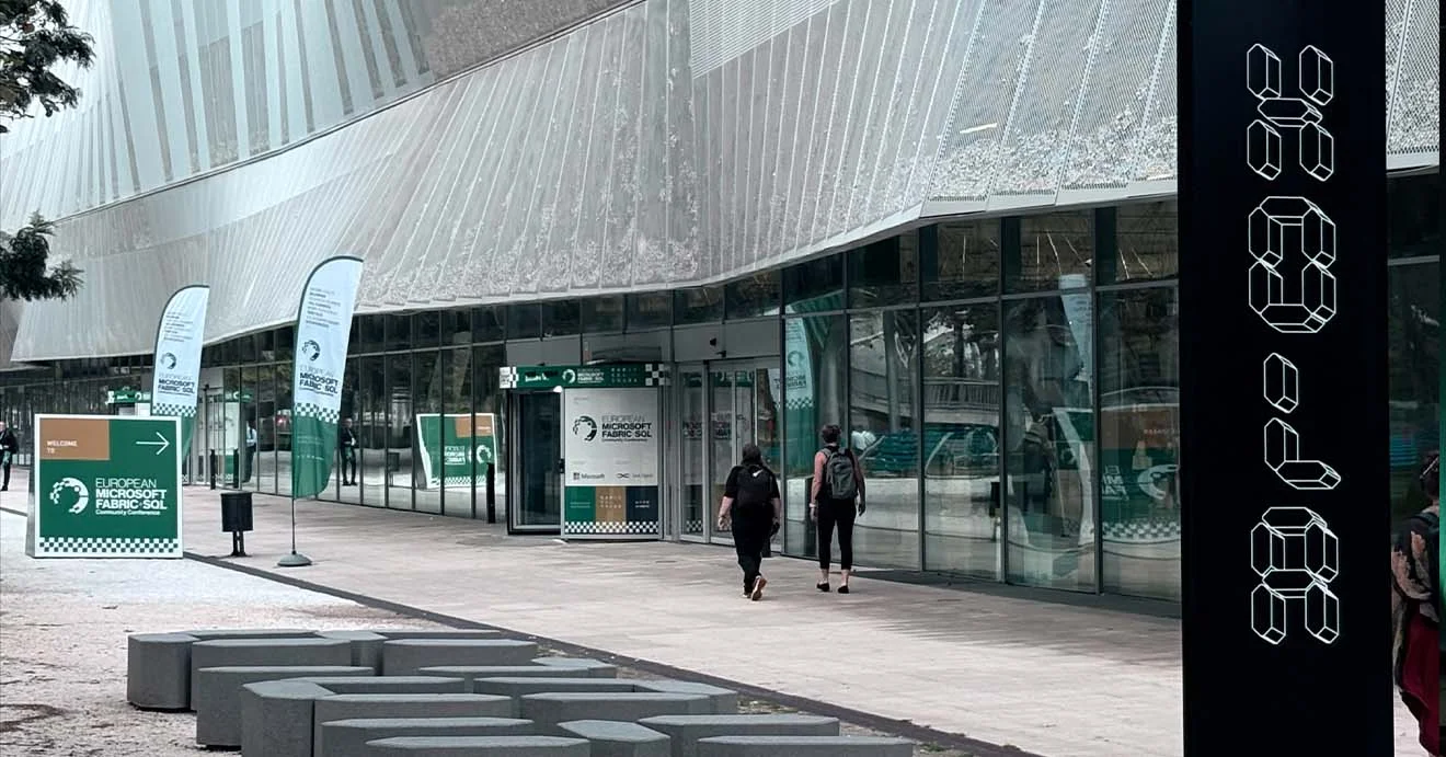 Vor dem Konferenzgebäude stehen Fahnen und Wegweiser zur Fabric + SQL Conference.